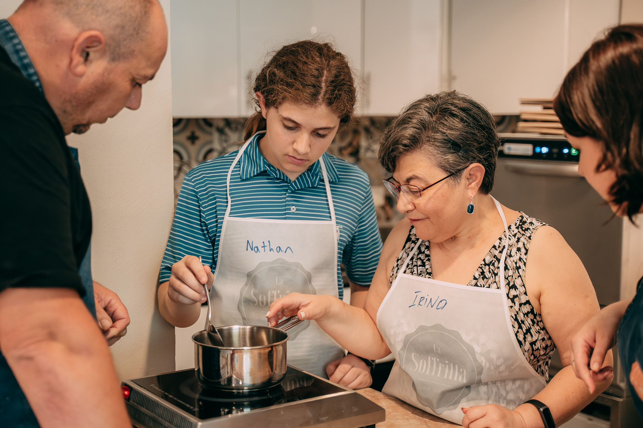 Chef aiuta due partecipanti ai fornelli