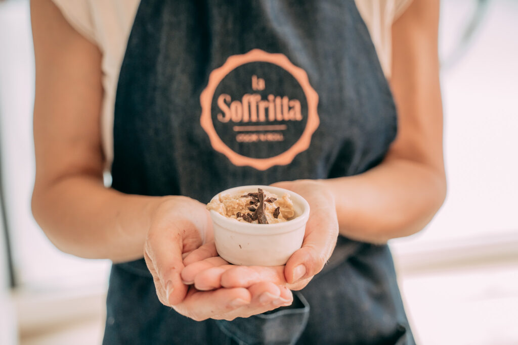 Mani reggono una coppetta di gelato artigianale creata durante una gelato class a La Soffritta