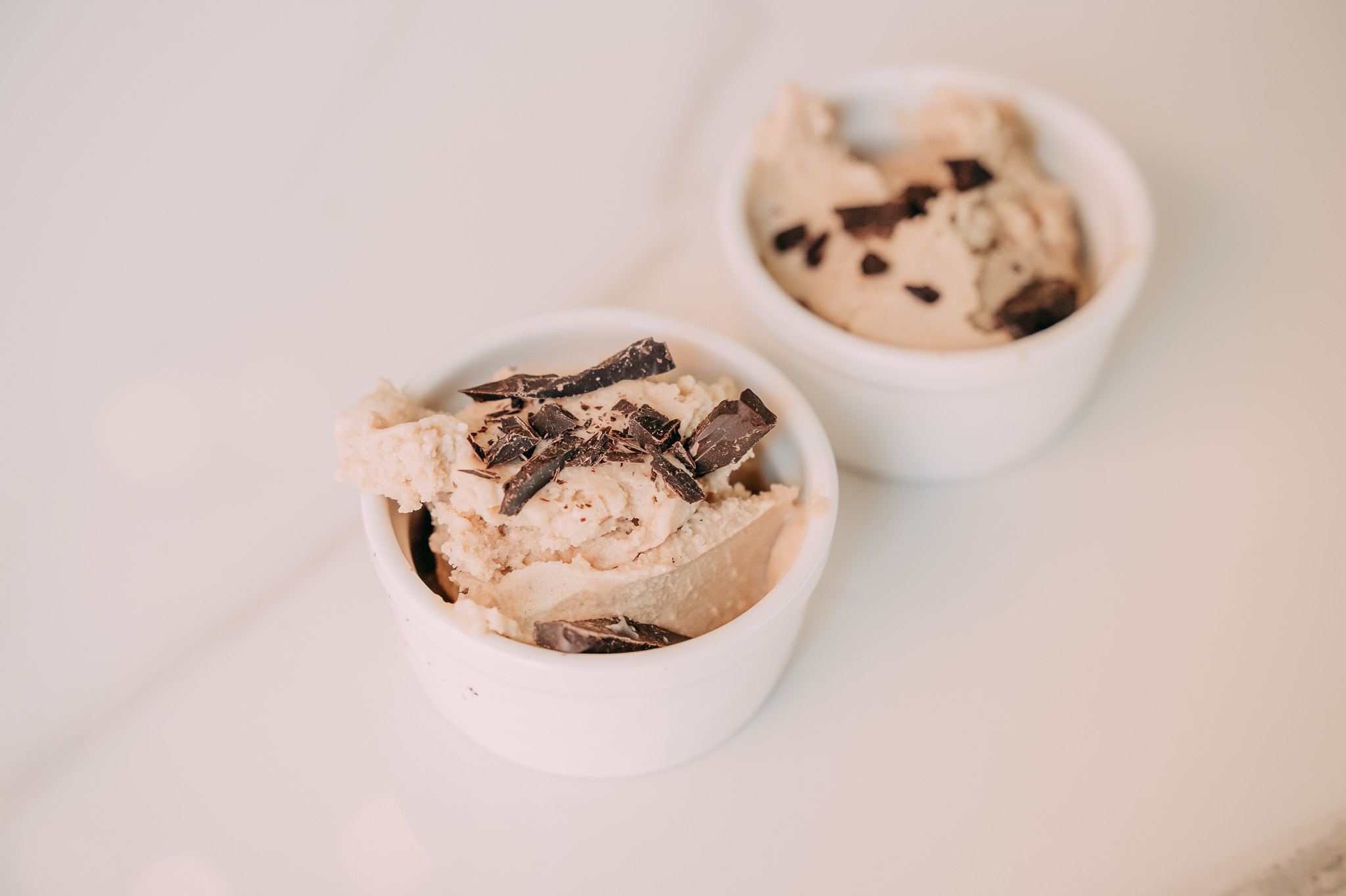 Due coppette con gelato artigianale al cioccolato e cialde su un piano di marmo