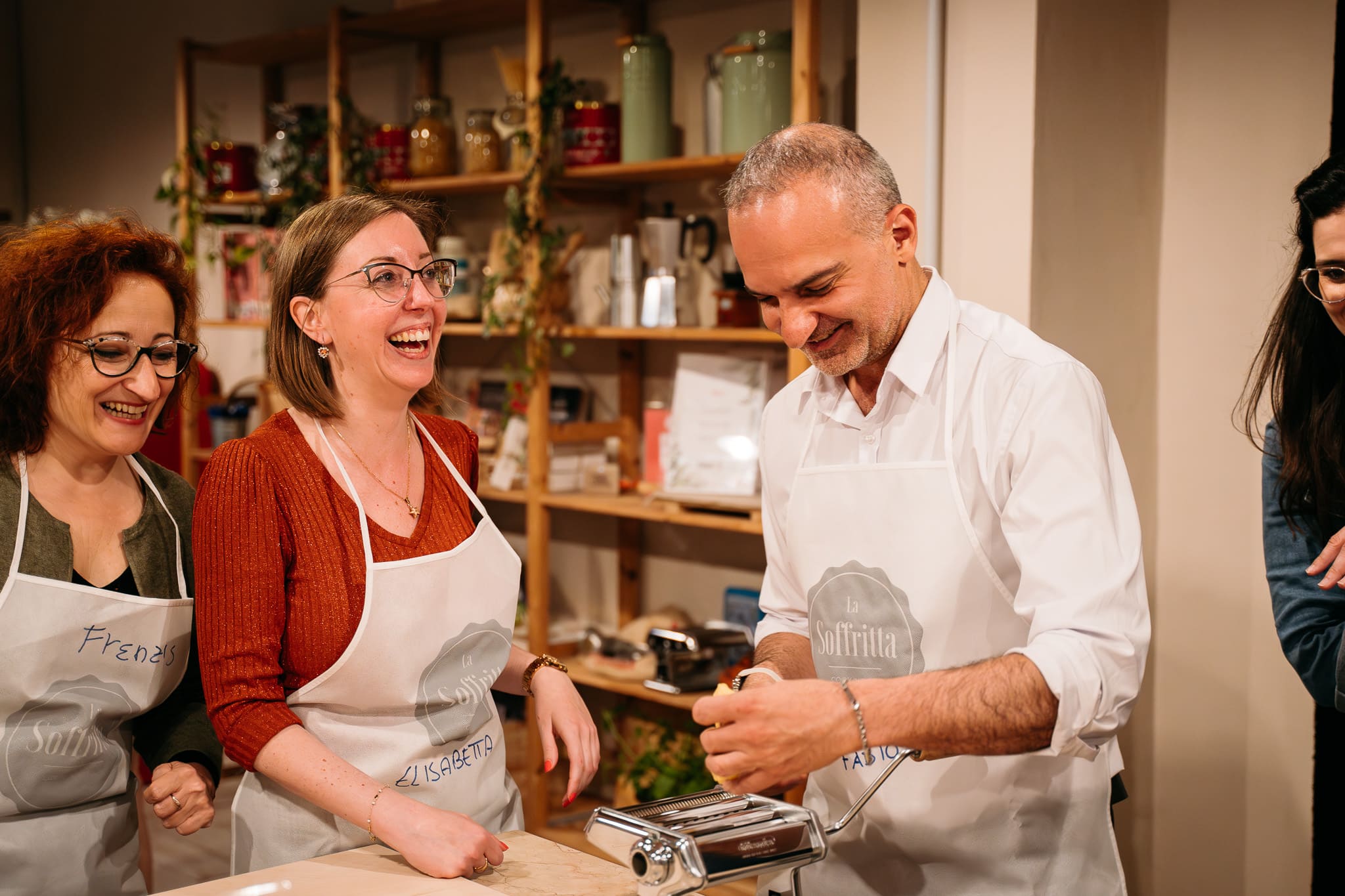 Chef mostra come stendere la pasta a due partecipanti della lezione