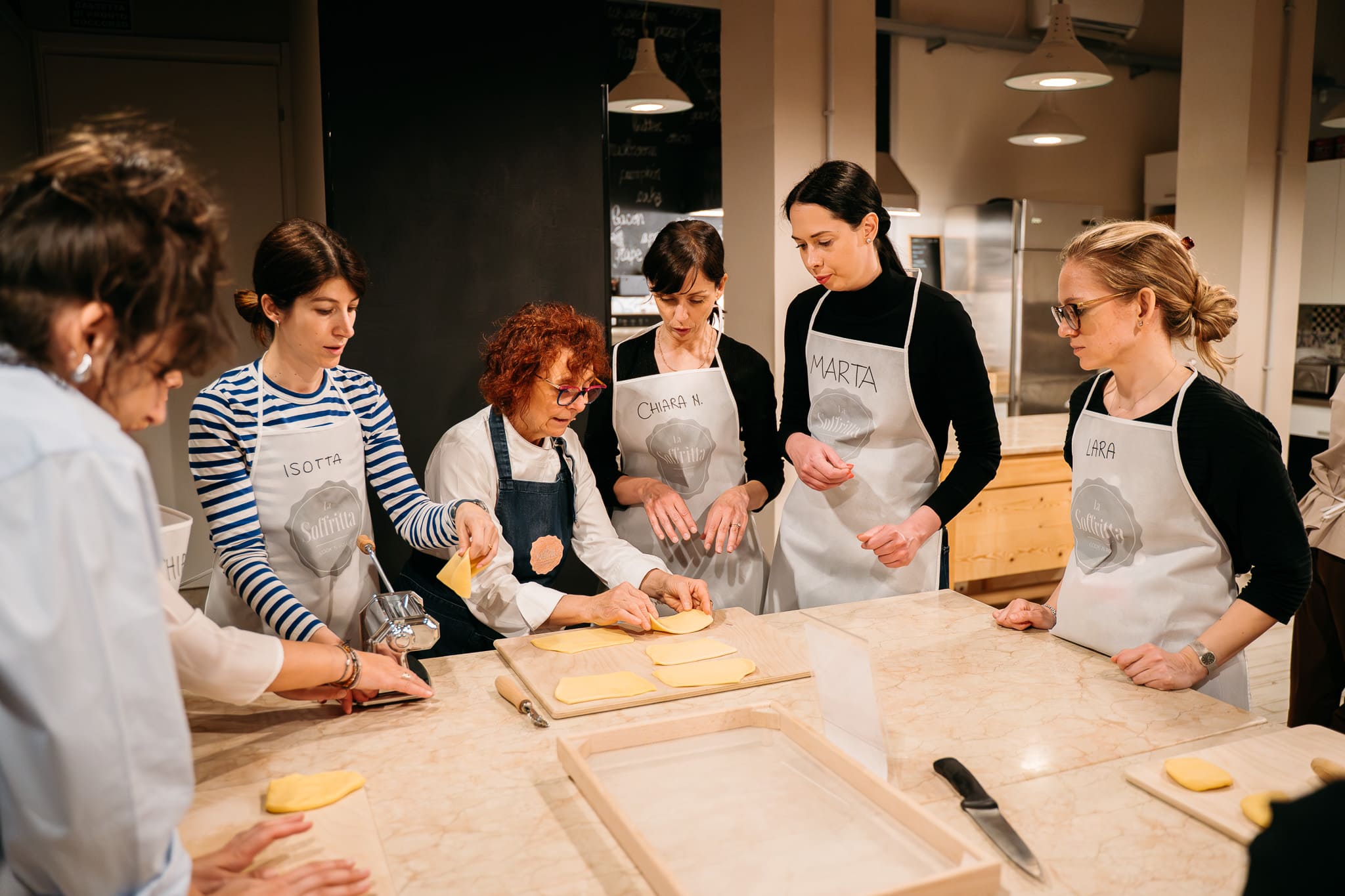 Chef spiega a un gruppo di persone come stendere la pasta fresca