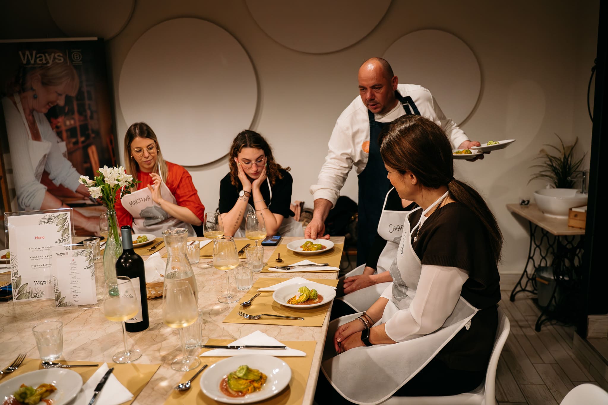 Chef serve la cena ai partecipanti della cooking