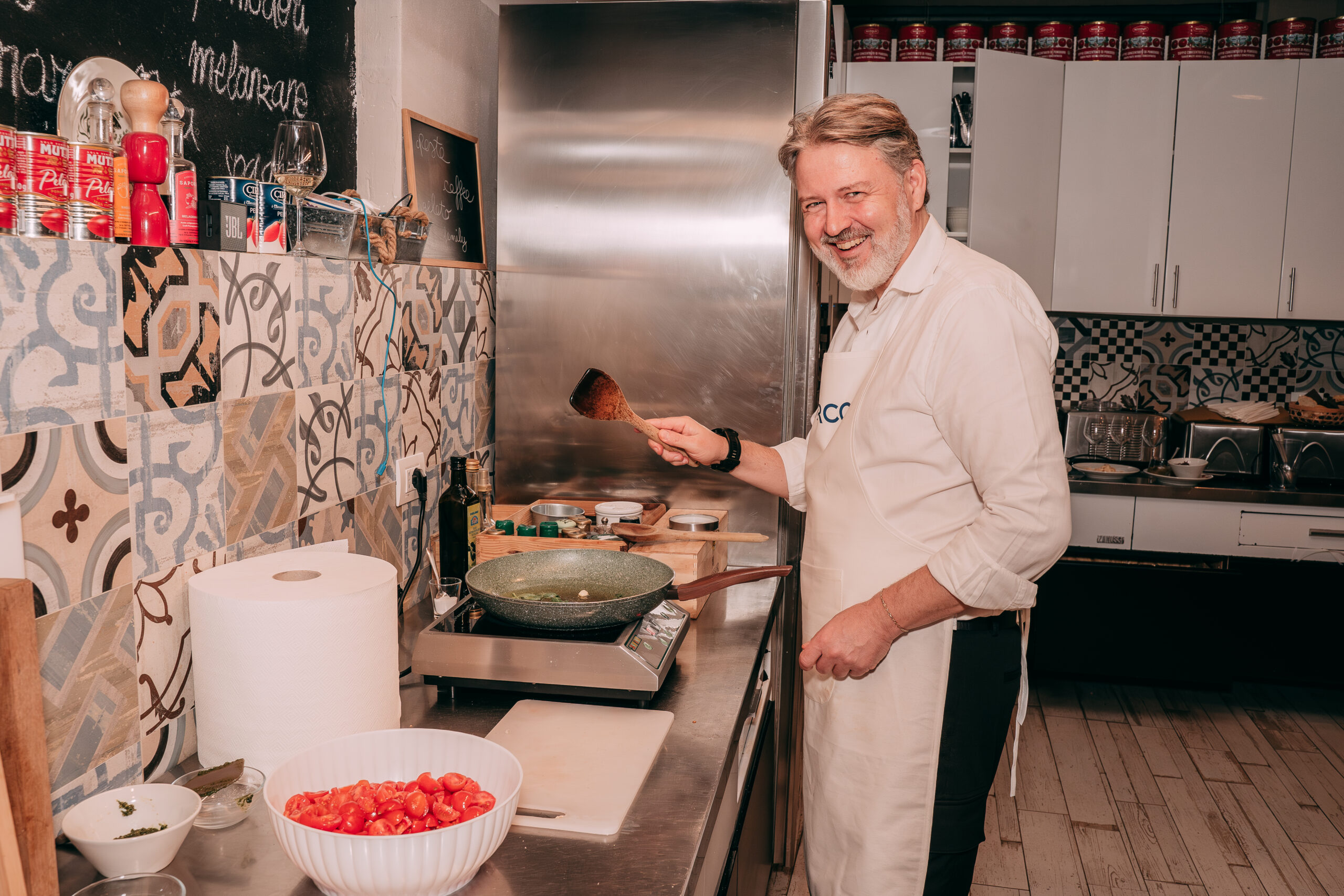 Partecipante di un Team Cooking mentre cuoce ai fornelli un soffritto