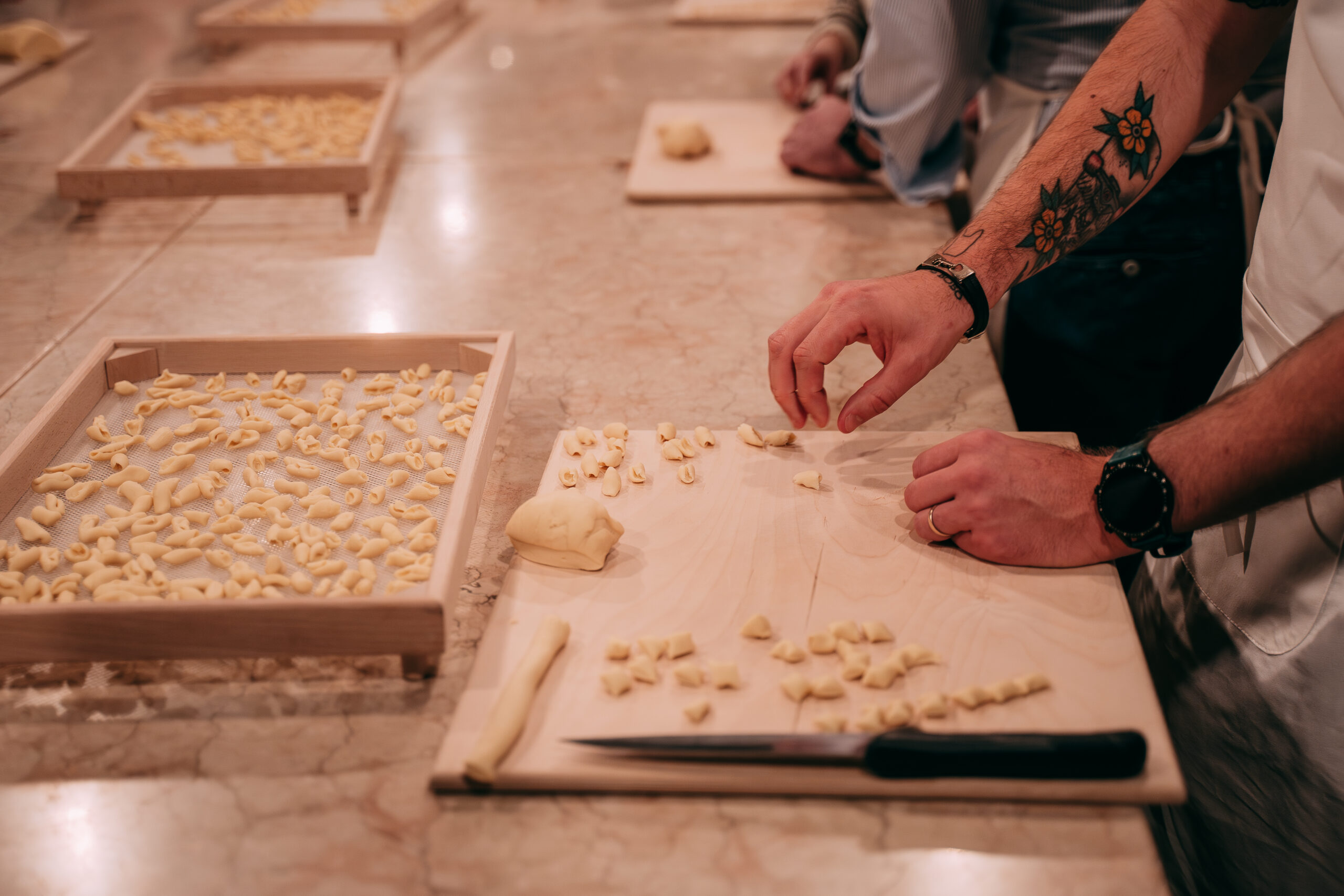 Mani che preparano pasta fresca