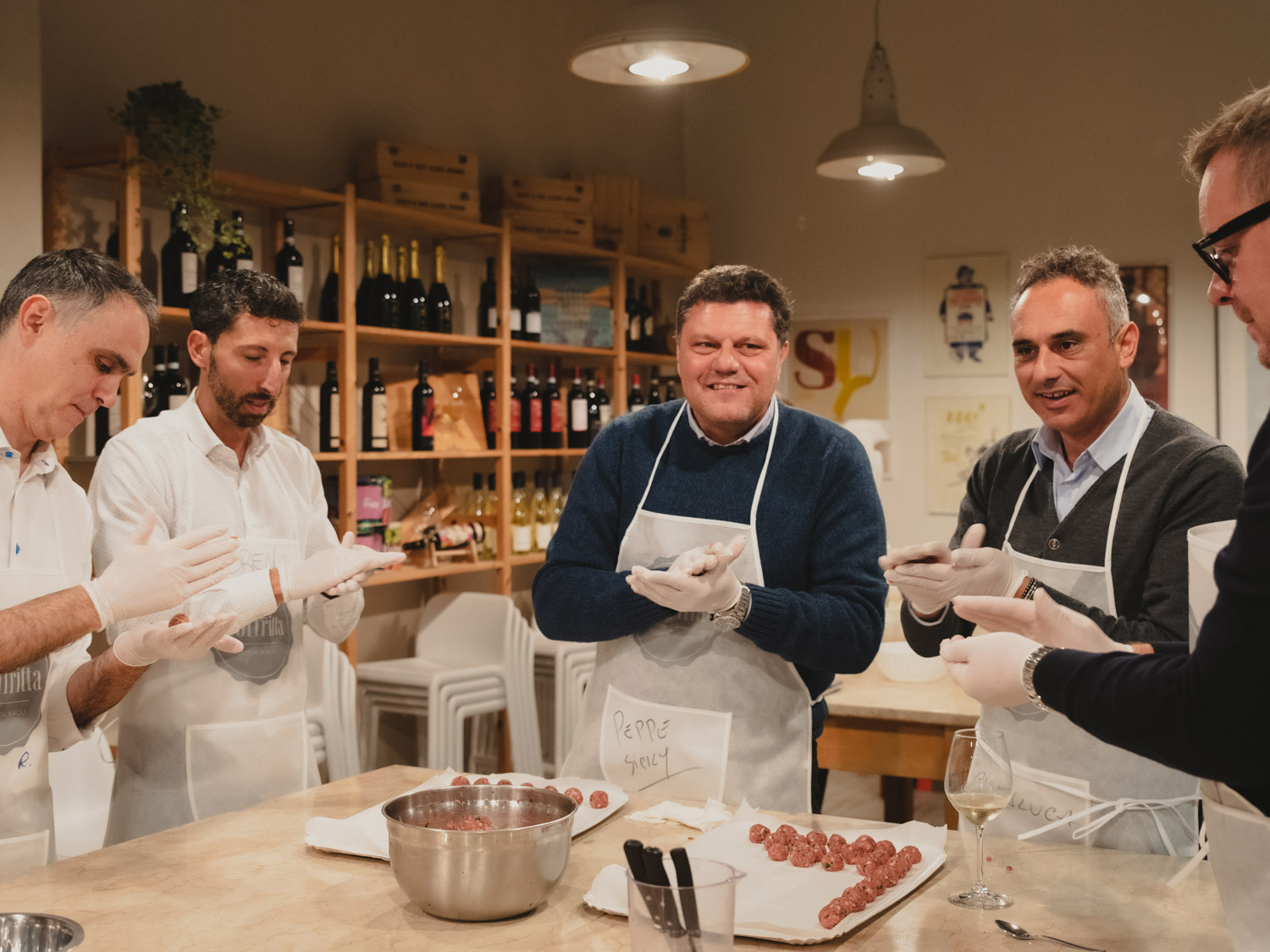 Gruppo di colleghi preparano insieme delle polpette durante un Team Cooking