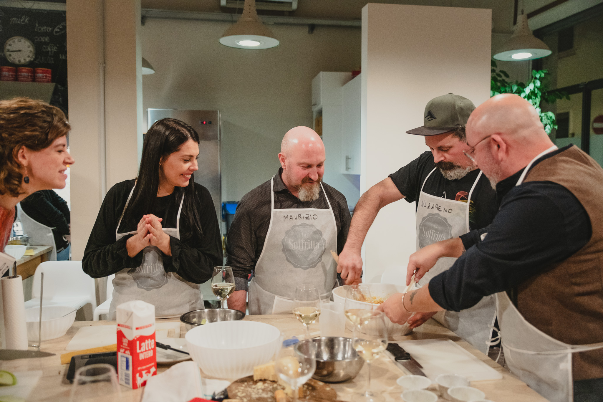 Gruppo di persone della Cooking guarda e interagisce mentre un partecipante impasta