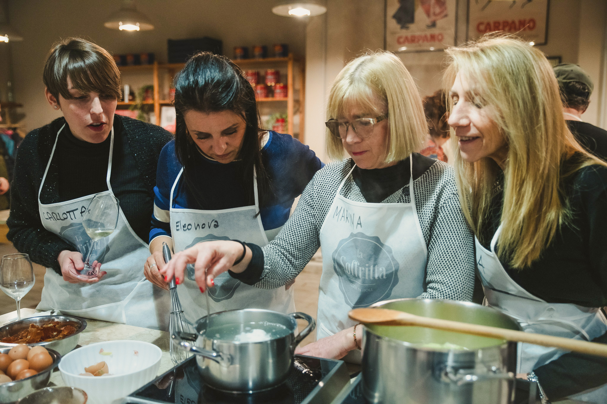 Quatto persone ai fornelli durante la Cooking a La Soffritta