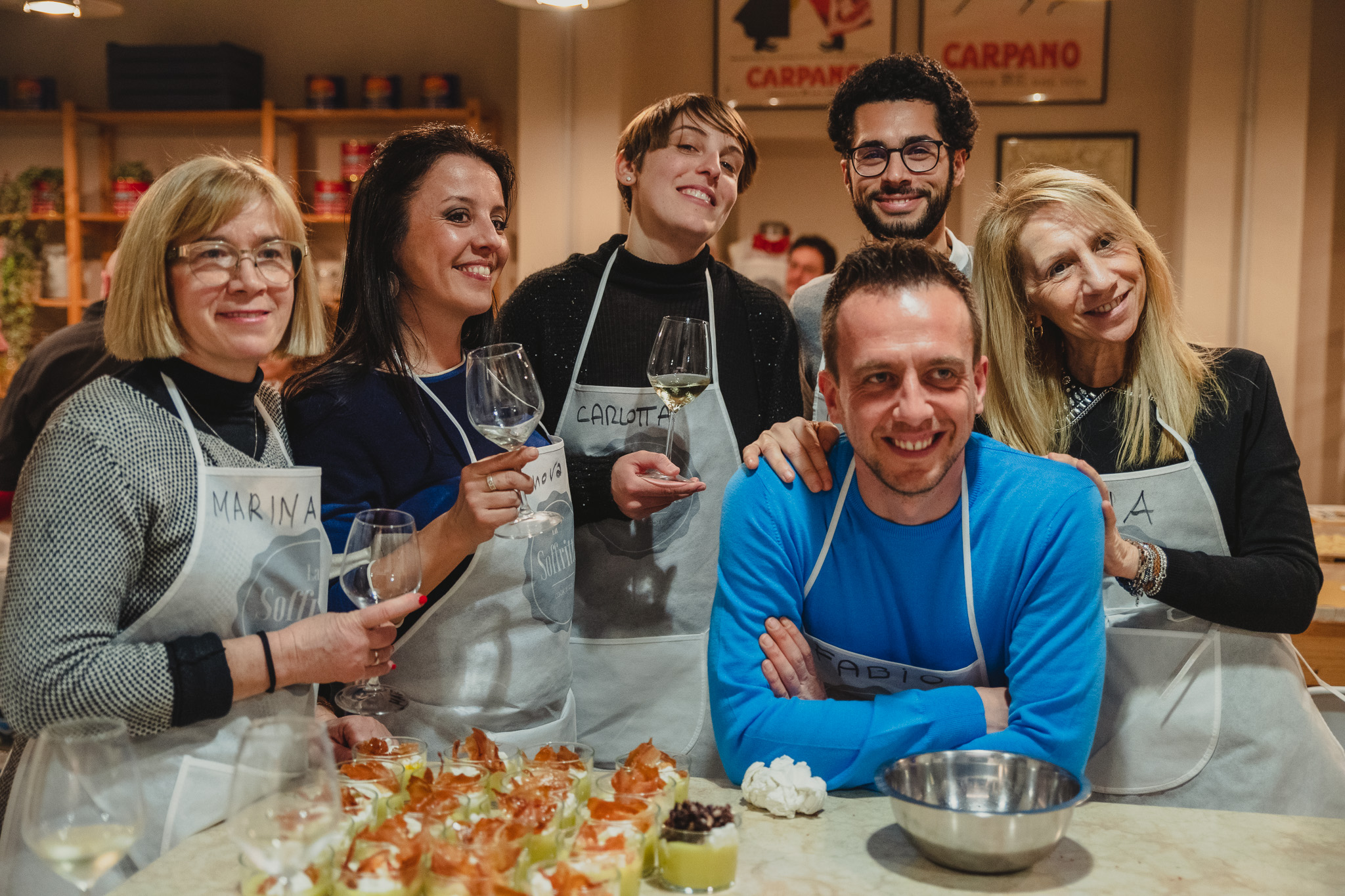 Gruppo sorridente che brinda durante l’attività di social cooking