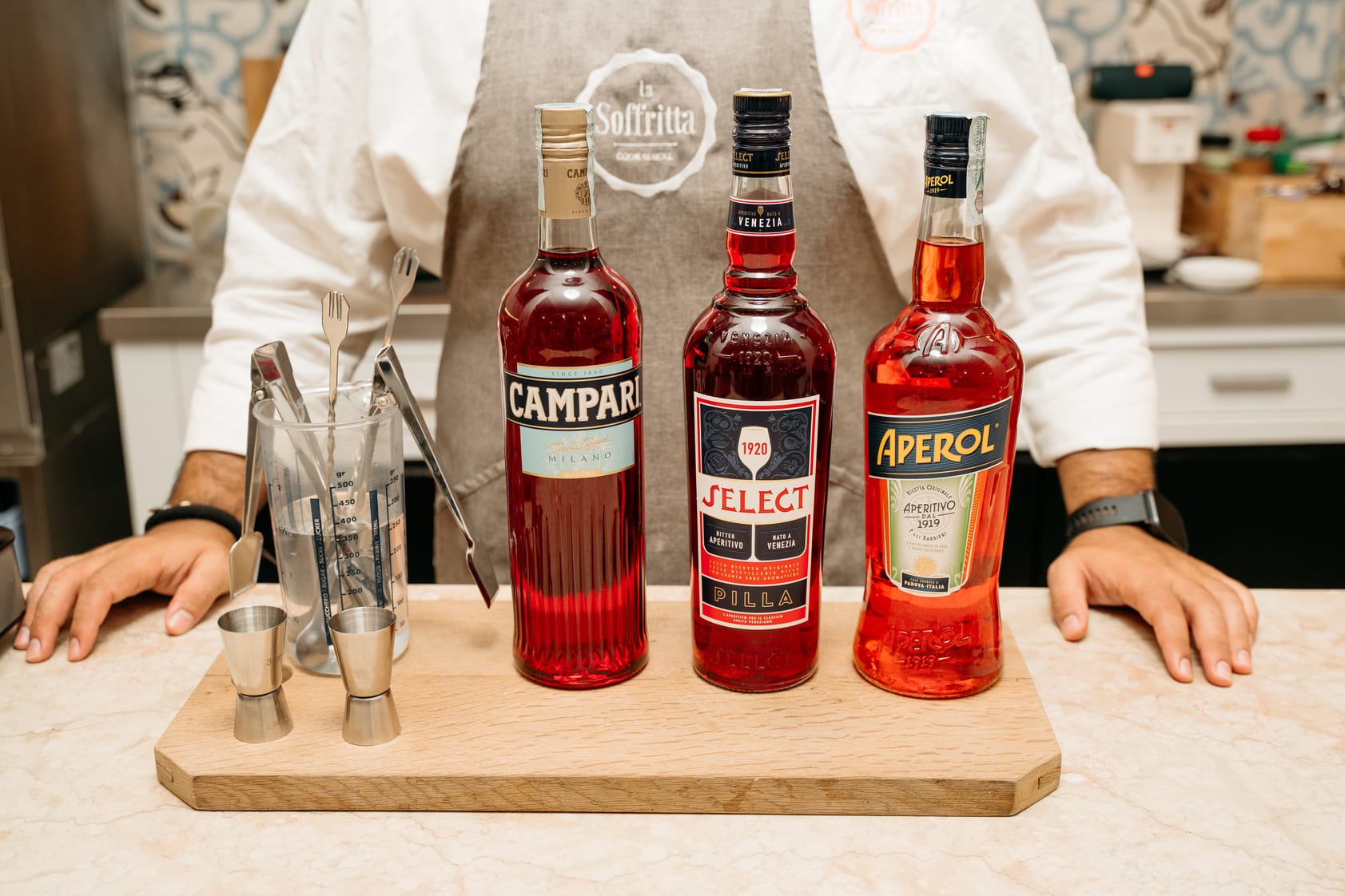 Close-up of Campari, Select and Aperol with bar tools on a wooden counter for a Spritz making class
